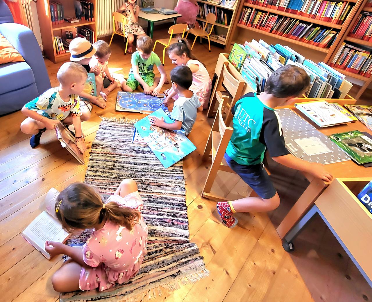 Besuch Kindergarten - Kinder mit Büchern am Boden
